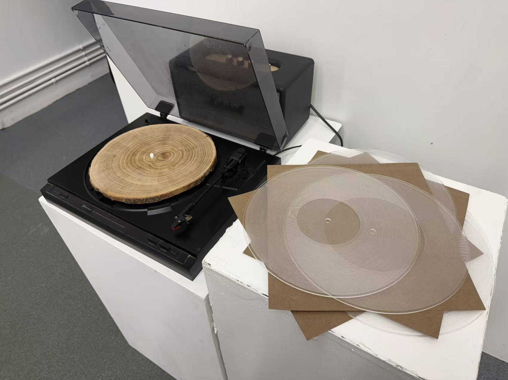 Recorded Rings sound object with acrylic disc, wood, speaker, and fixed turntable
