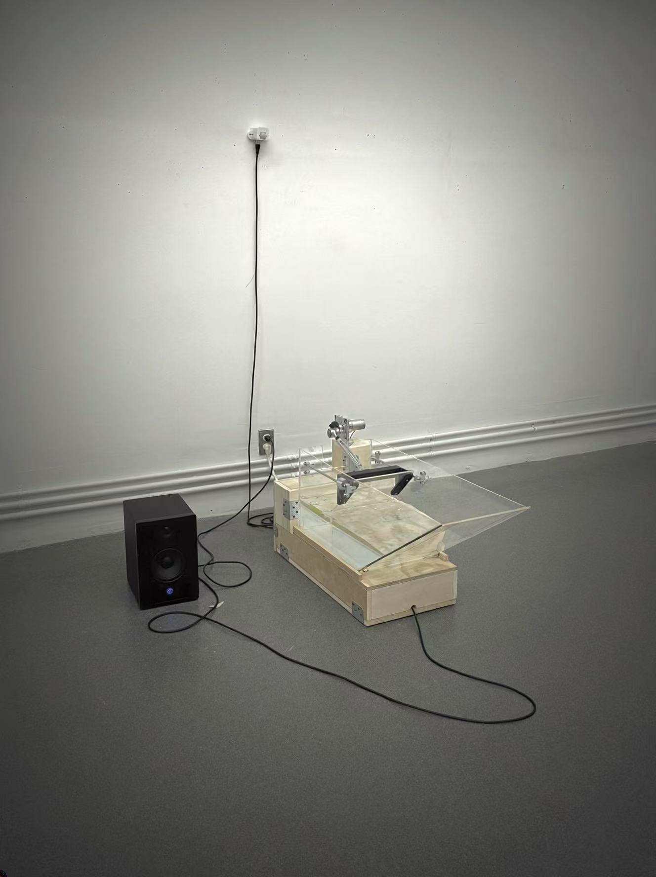 The Wave installation with an acrylic water tank, motor, sensor, and speaker